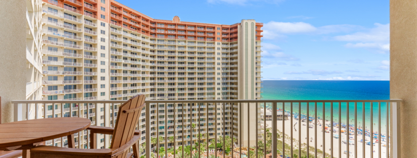 The beautiful interior living area and private balcony view of Condo 1309, a luxury vacation rental at the Shores of Panama resort in Panama City Beach, Florida.