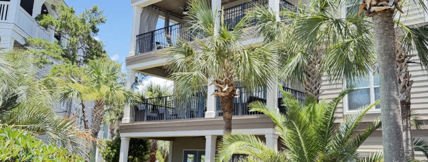Luxury multi-story Panama City Beach vacation rental home with palm trees and paved walkway