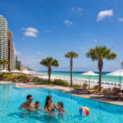 Family enjoying a Panama City Beach condo pool near the beach with Emerald Beach Rentals