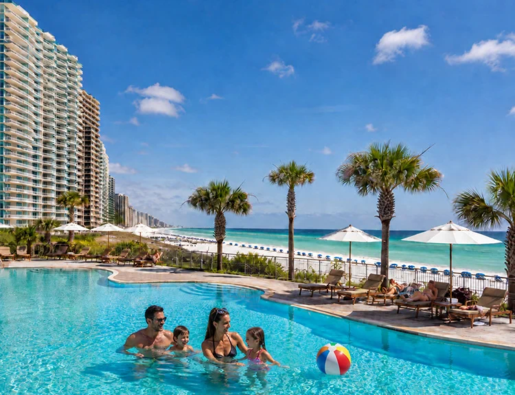 Family enjoying a beachfront condo pool in Panama City Beach Family enjoying a beachfront condo pool in Panama City Beach