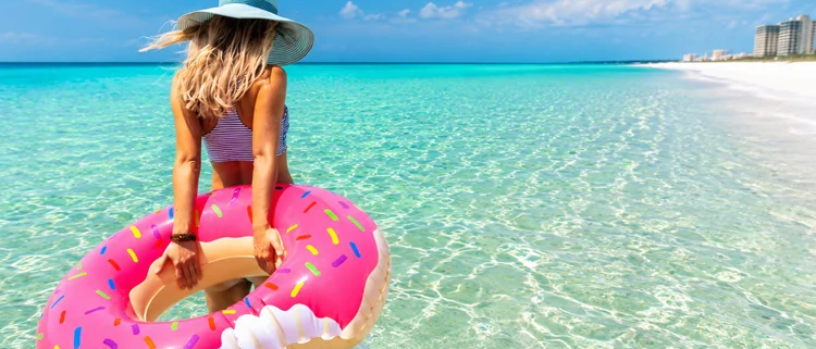 Woman with inflatable float wading into Panama City Beach