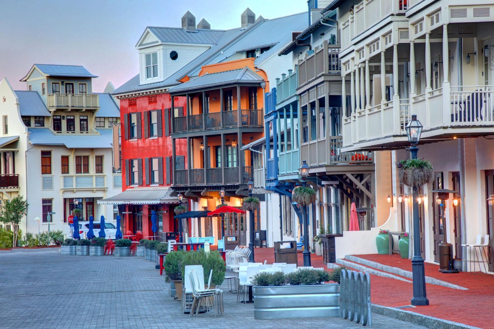 Rosemary Beach street lined with colorful buildings with wrought-iron balconies and sidewalk planters